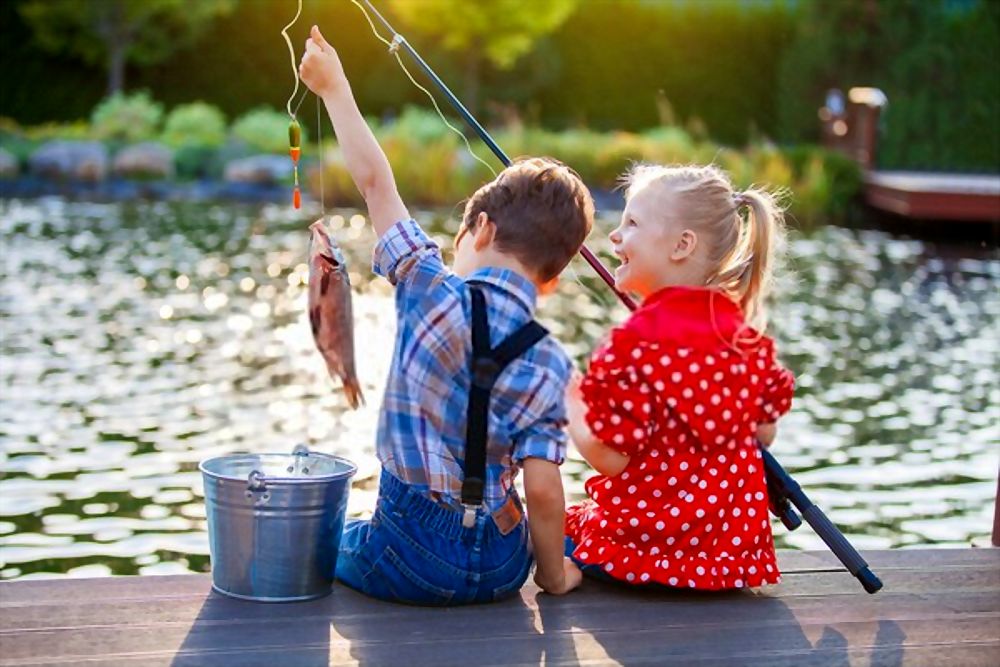 Little boy and girl fishing in a river