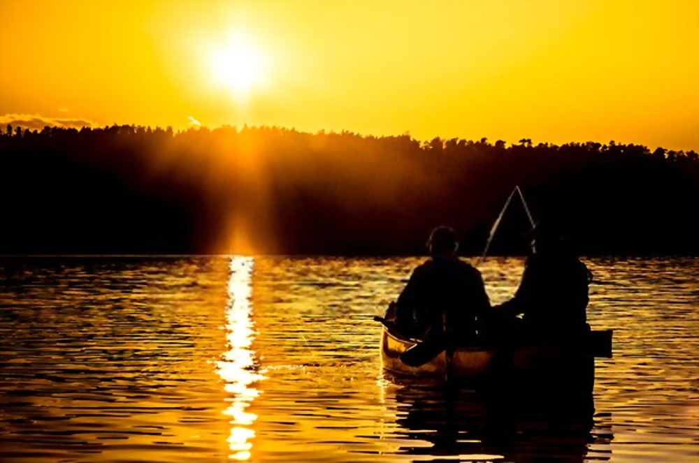 two fishermens in a canoe on a lake